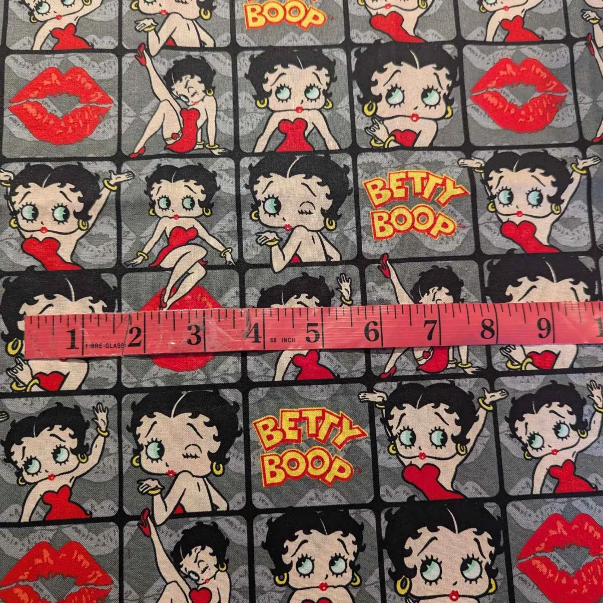 Betty Boop poses in 2" frames on grey fabric