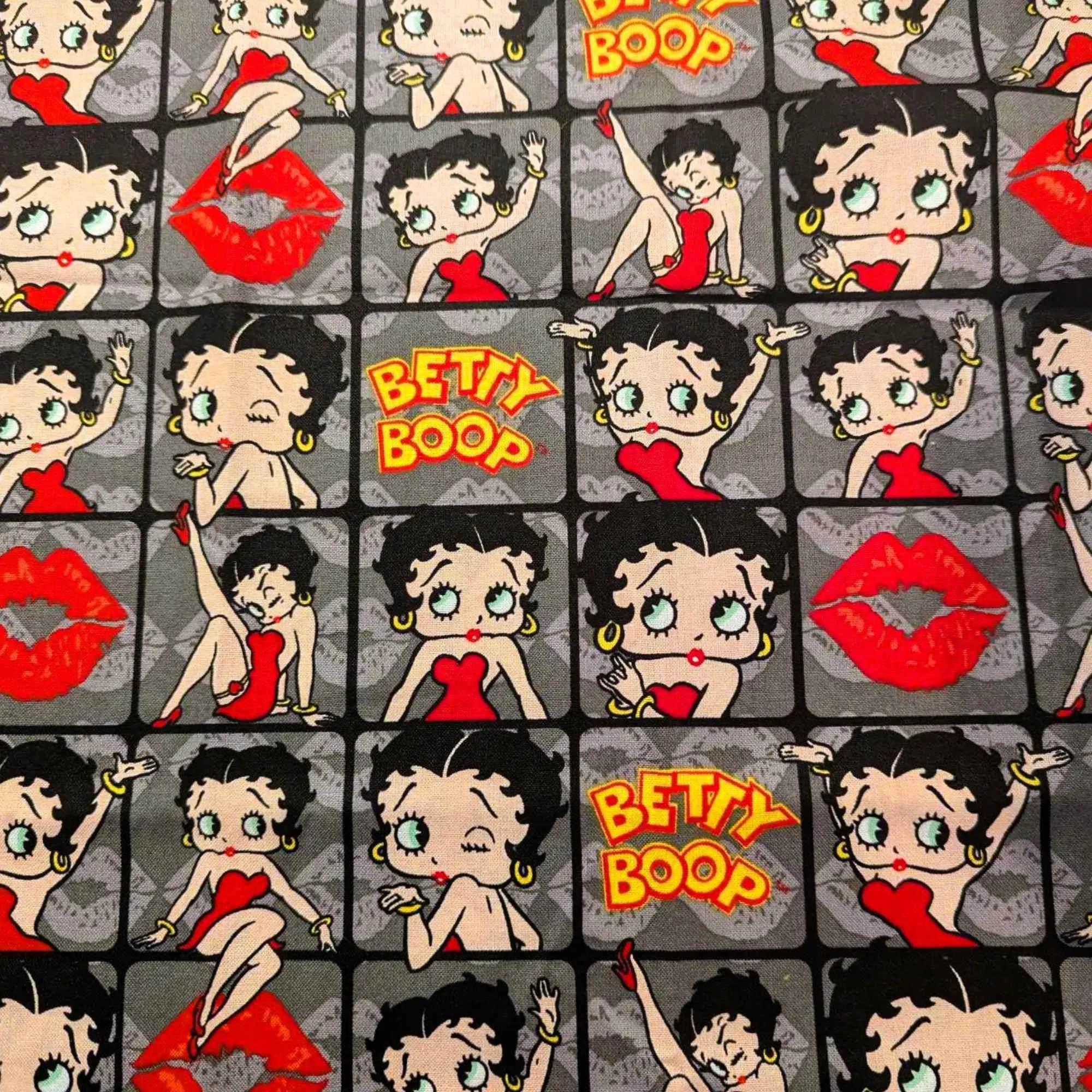 Betty Boop poses in 2" frames on grey fabric