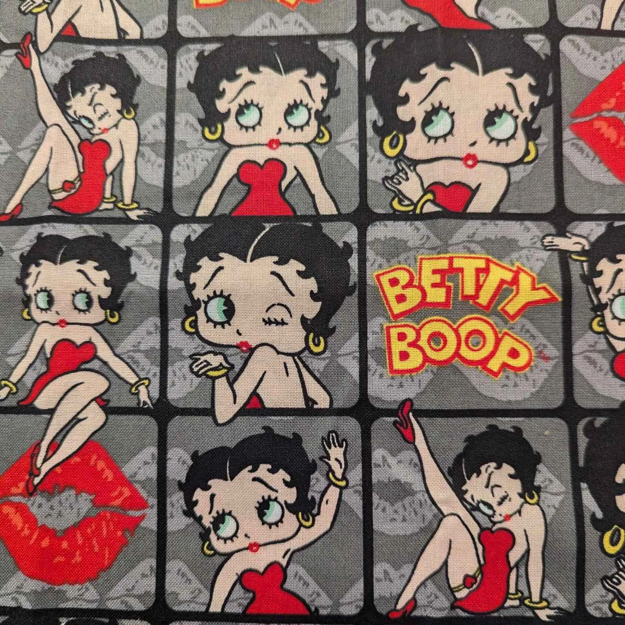 Betty Boop poses in 2" frames on grey fabric